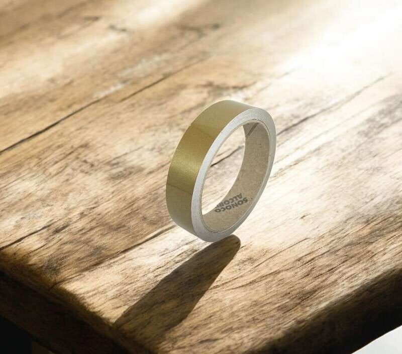 Goldene Zierstreifen auf Holzoberfläche, glänzende selbstklebende Dekorstreifen für Fahrzeuge.