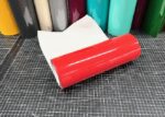 ORACAL 751C-031 Rot glänzende Plotterfolie, aufgerollt mit weißem Trägerpapier auf einer karierten Schneidematte