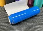Mactac MACal 9837-00 PRO SL Luminous Blau glänzende Plotterfolie mit weißem Trägerpapier auf einer karierten Schneidematte